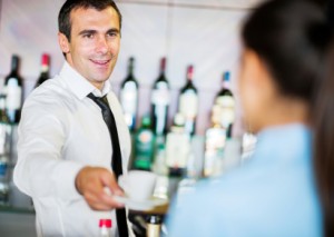 Bartender serving a coffee to a woman.